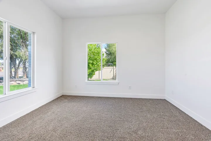 Neutral white walls complement the textured gray carpeting