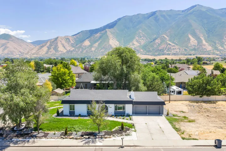 Single-story residence featuring a dark gray roofline, a two-car garage, and a concrete driveway