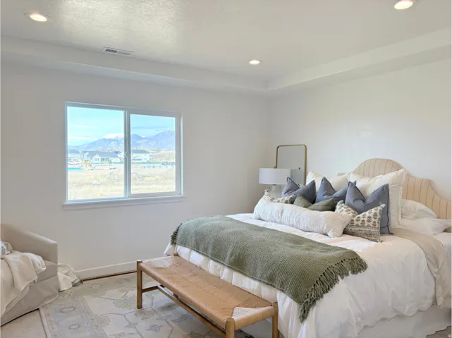Bedroom featuring a large window, recessed lighting, and a tray ceiling