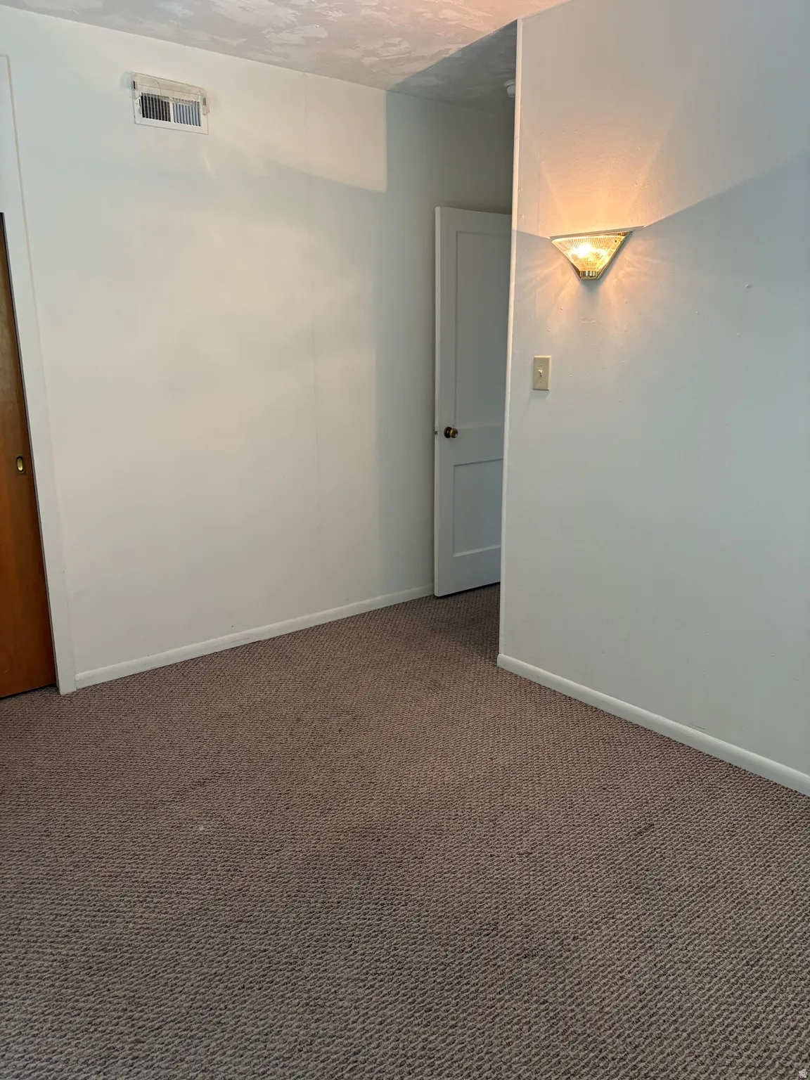 Spacious room featuring neutral wall finishes, carpeted flooring, and recessed lighting