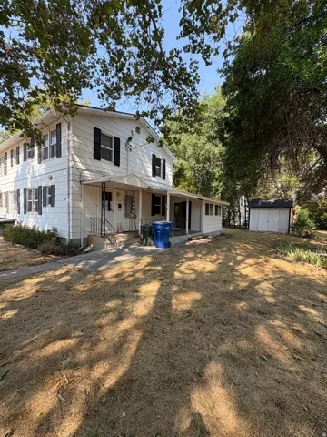 Two-story exterior with white siding and black window shutters