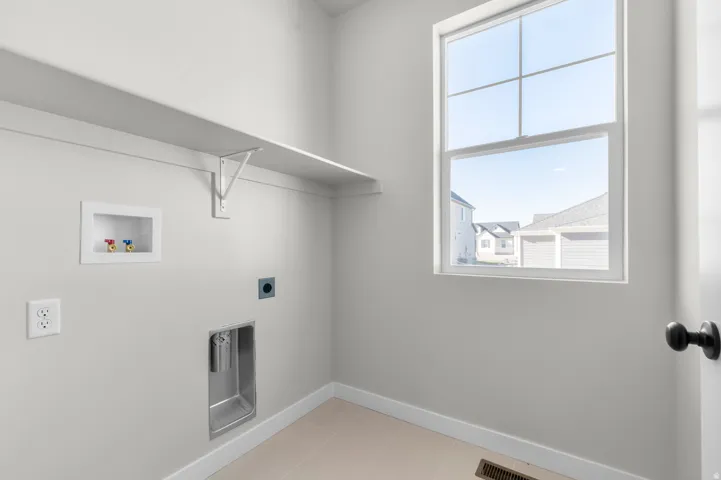 Upper shelving unit with support brackets, single window, power outlets, and tile flooring