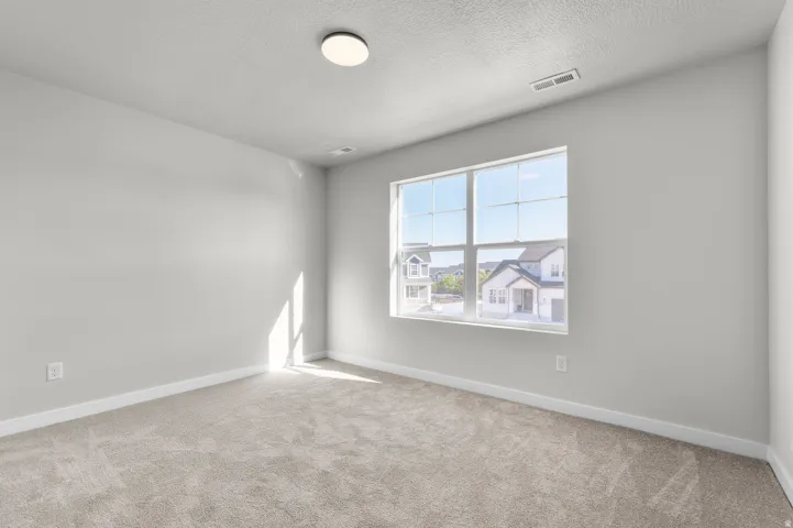 Neutral-toned carpeting, white walls, and a multi-pane window