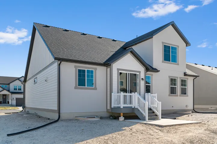 Multi-level exterior featuring stucco and horizontal siding, a private deck with white railings, a ground-level concrete patio, and a shingle roof