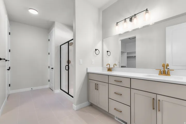 Dual vanity with white countertops, gold-tone faucets, and integrated sinks