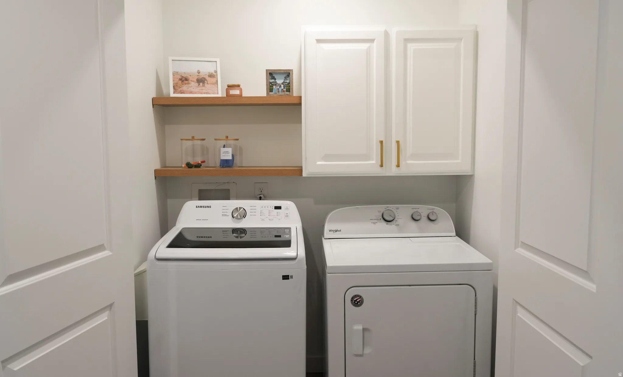 Dedicated laundry space featuring a white top-load washing machine and white dryer