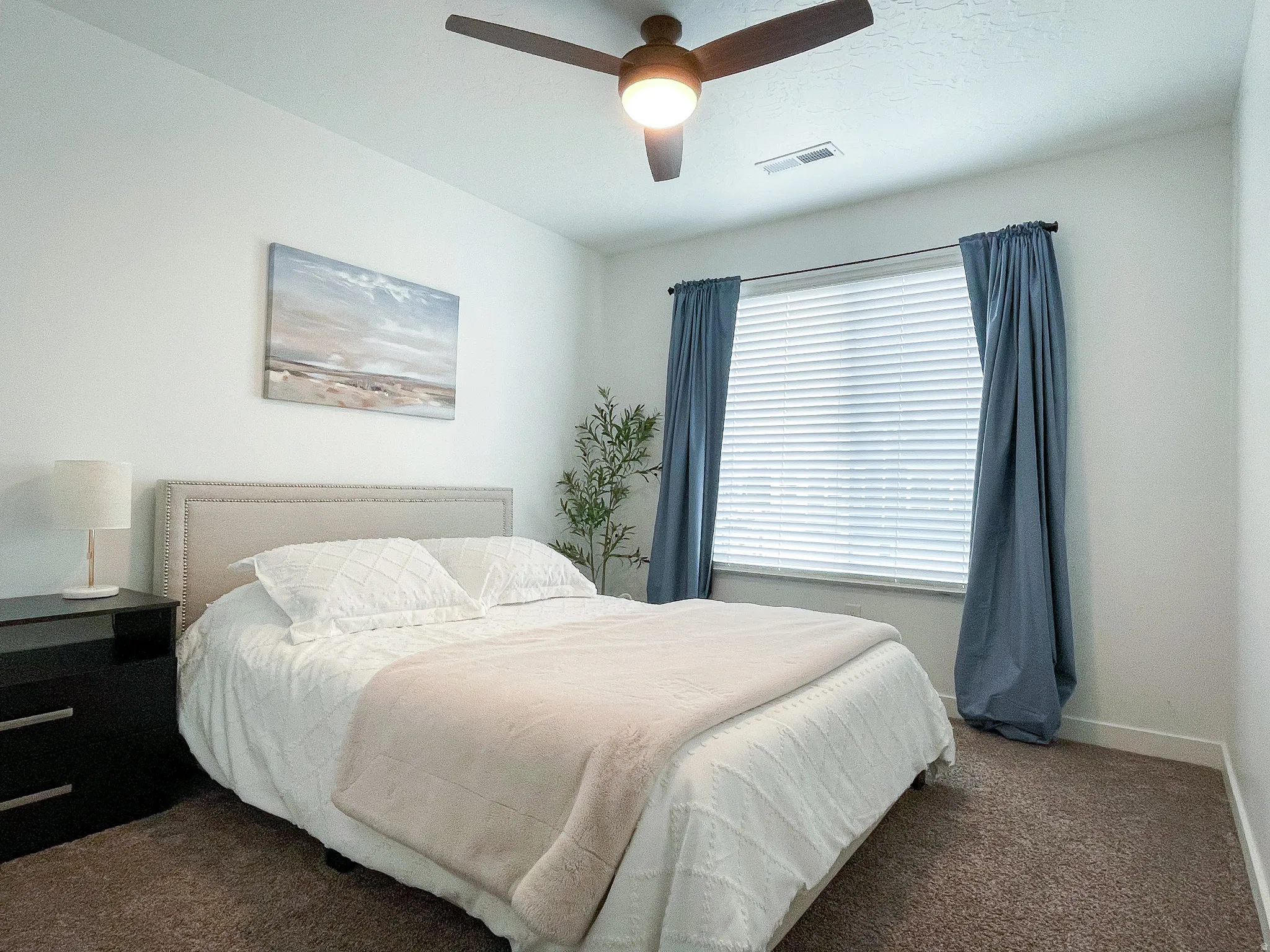 Bedroom featuring a ceiling fan with integrated lighting, a window with blinds and drapes, and neutral wall tones