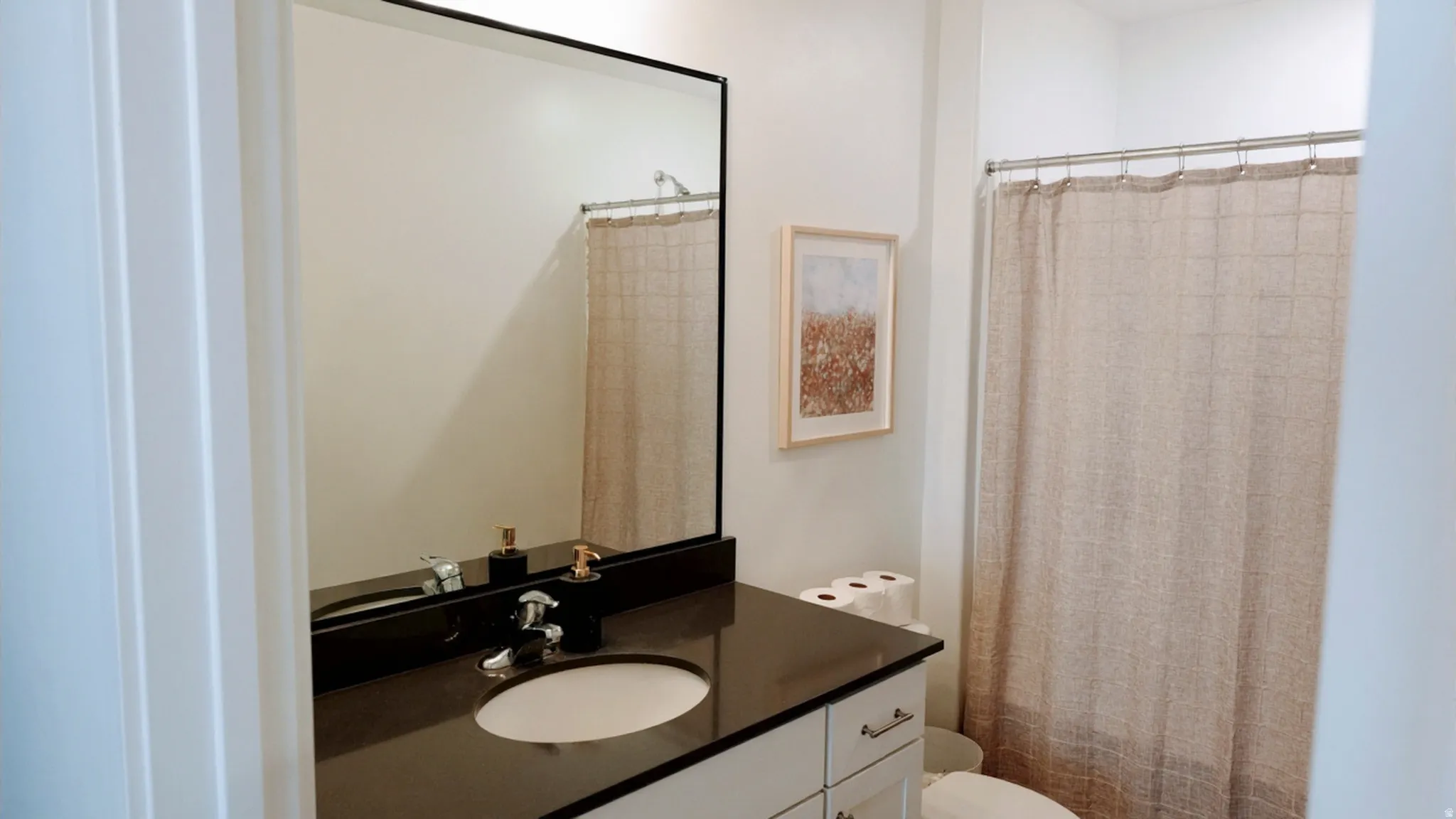 Bathroom featuring a black countertop vanity with an undermount sink and chrome faucet