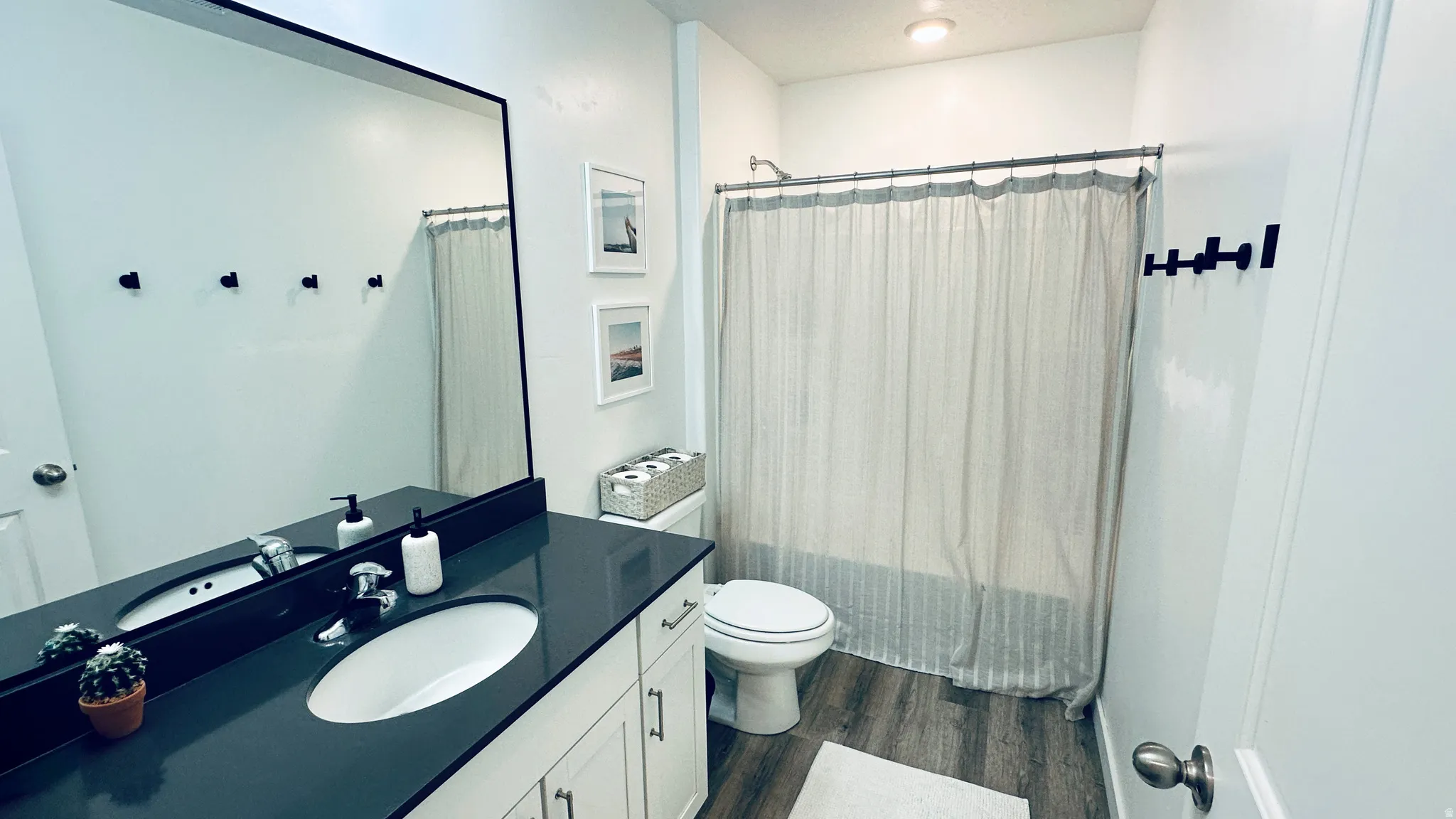 Bathroom featuring a single vanity with a dark countertop and integrated sink
