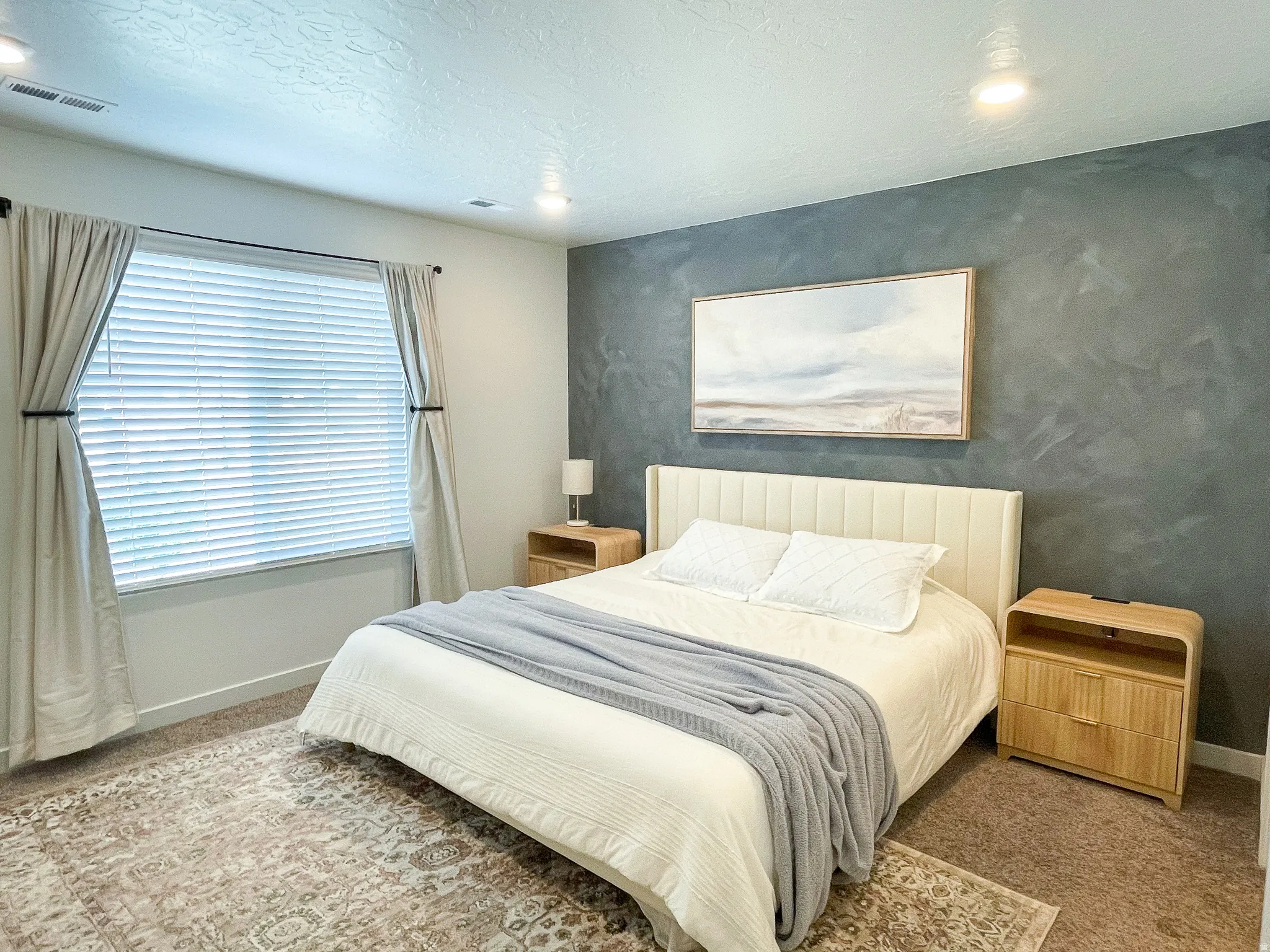 Bedroom featuring a textured accent wall and recessed lighting