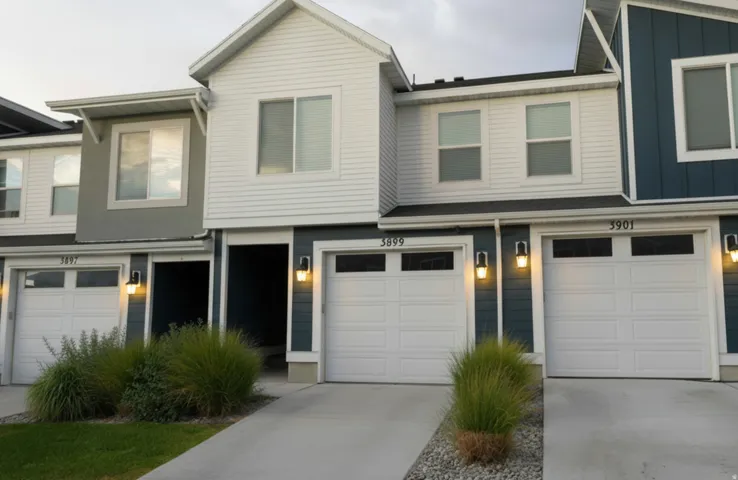 Contemporary townhome-style exterior featuring a combination of white siding and blue-gray paneling