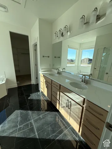 Dual vanity with light wood-finish cabinetry, white countertops, and undermount sinks
