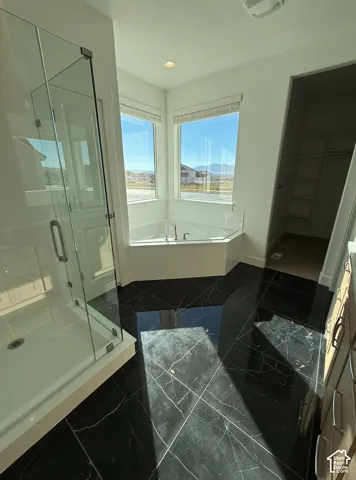 Corner soaking tub with a deck-mounted faucet, complemented by a glass-enclosed shower