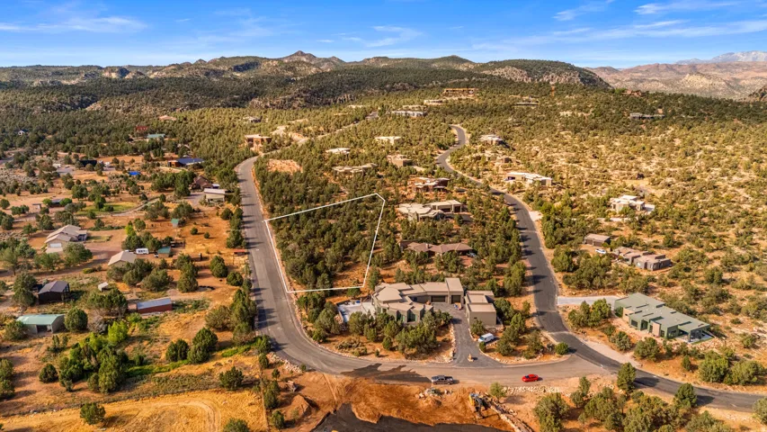 Expansive residential lot outlined, featuring natural desert landscaping and scattered trees