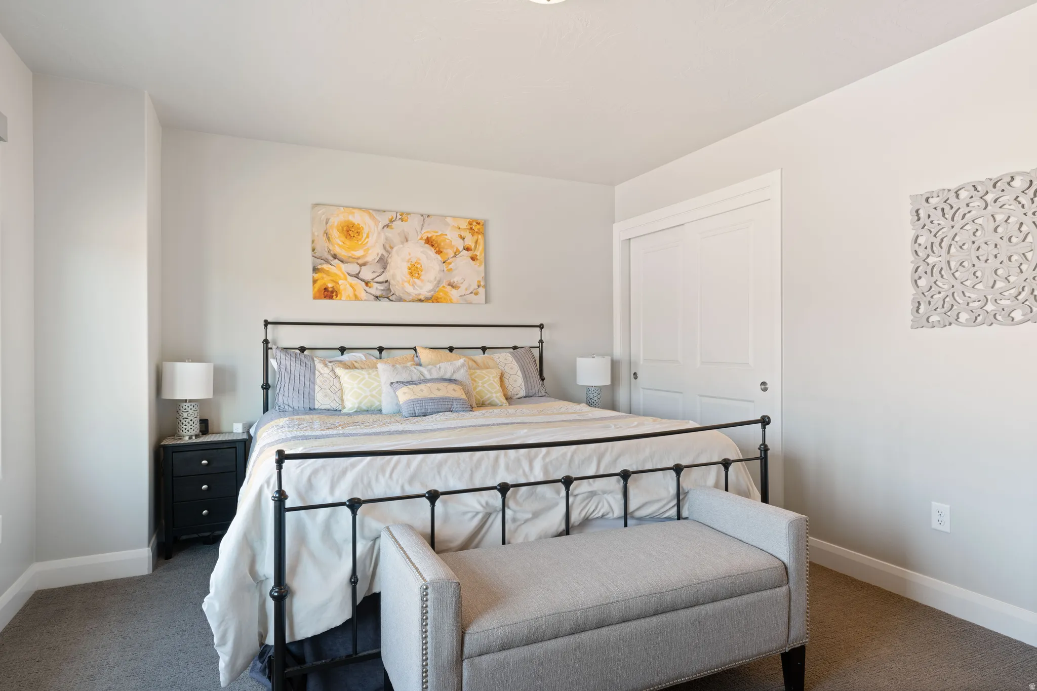 Spacious bedroom featuring light-colored walls and soft carpet flooring