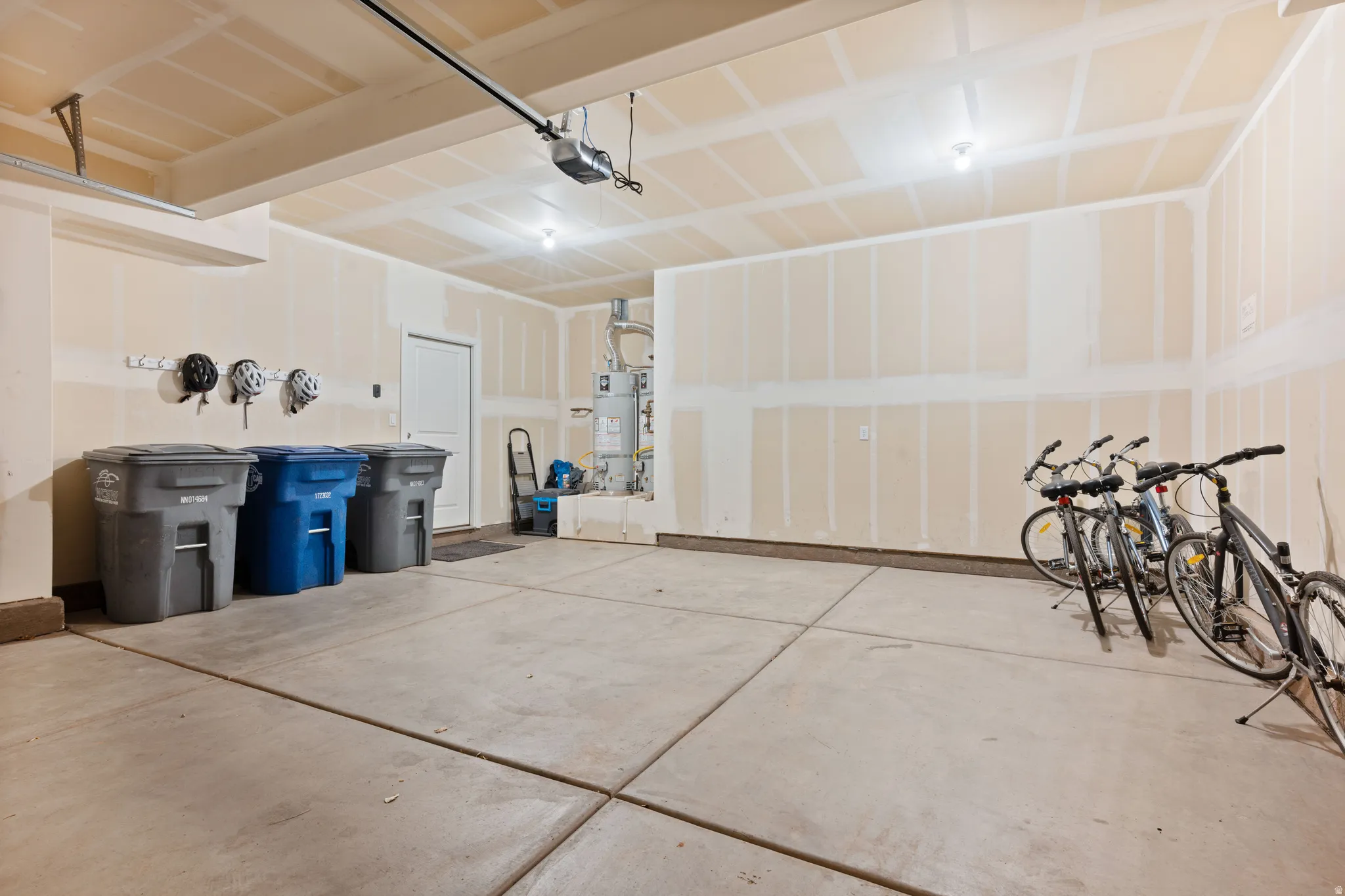 Spacious two-car garage with concrete flooring, automatic garage door opener, and integrated lighting