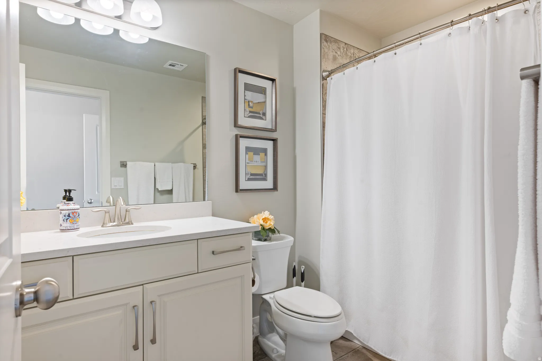 Bathroom featuring a vanity with an undermount sink, a chrome faucet, and a large mirror
