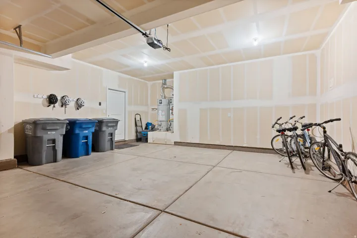 Spacious two-car garage with concrete flooring, automatic garage door opener, and integrated lighting