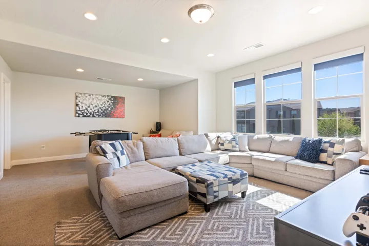 Spacious room featuring multiple large windows, recessed ceiling lighting, a contemporary ceiling fixture, and neutral wall tones