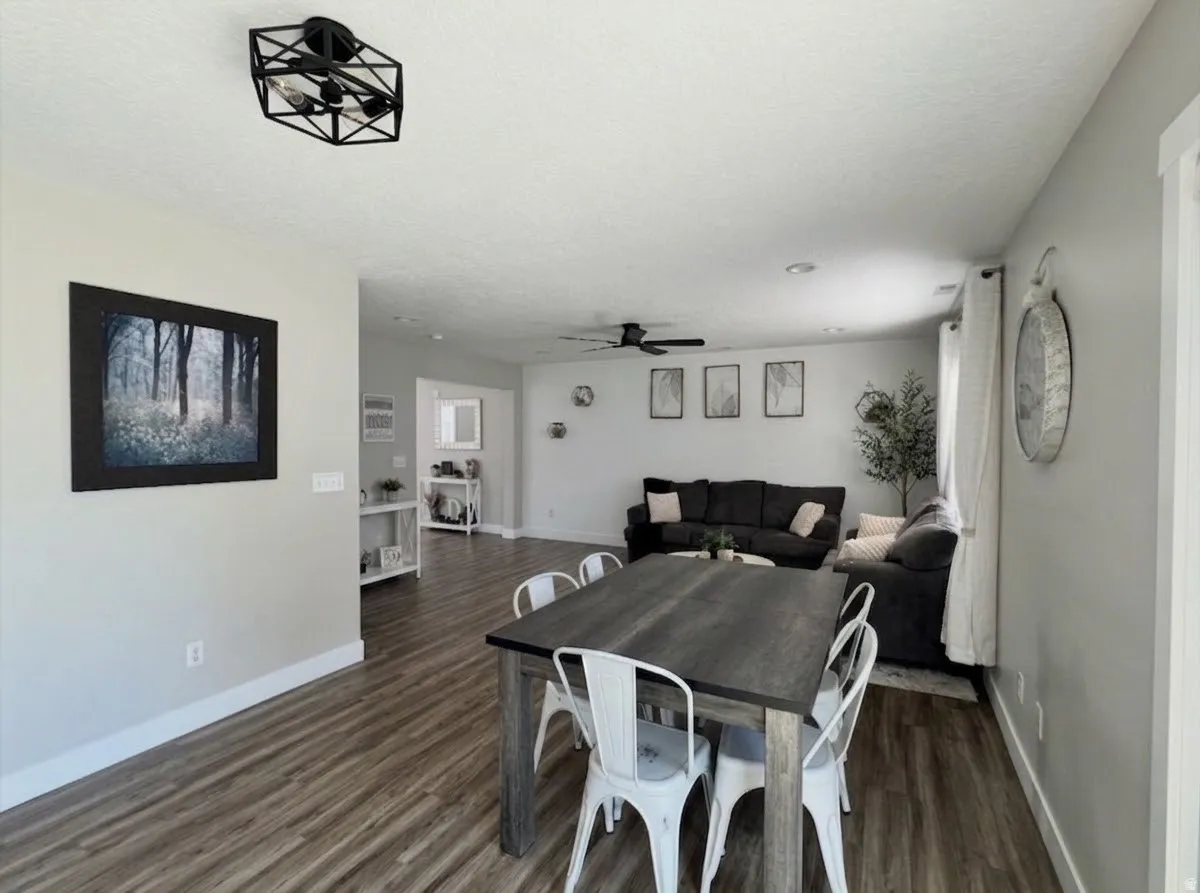 Open-concept living area with wood-finish flooring, recessed lighting, and a ceiling fan.  AI enhanced design concept.