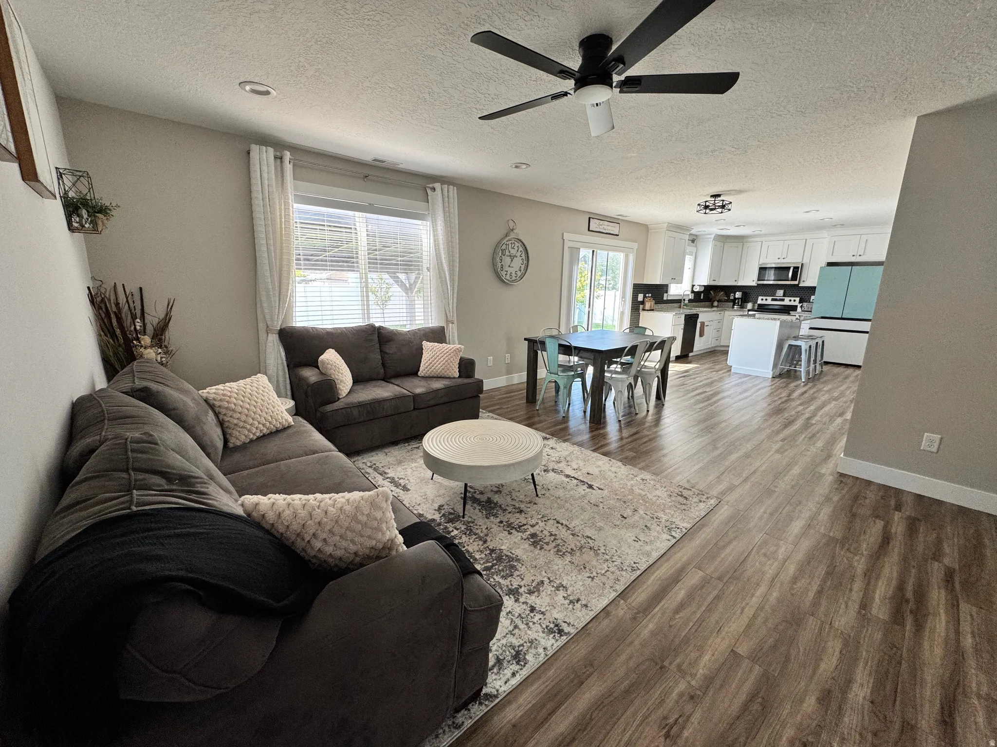 Open-concept living space featuring wood-finish flooring, recessed lighting, and a ceiling fan