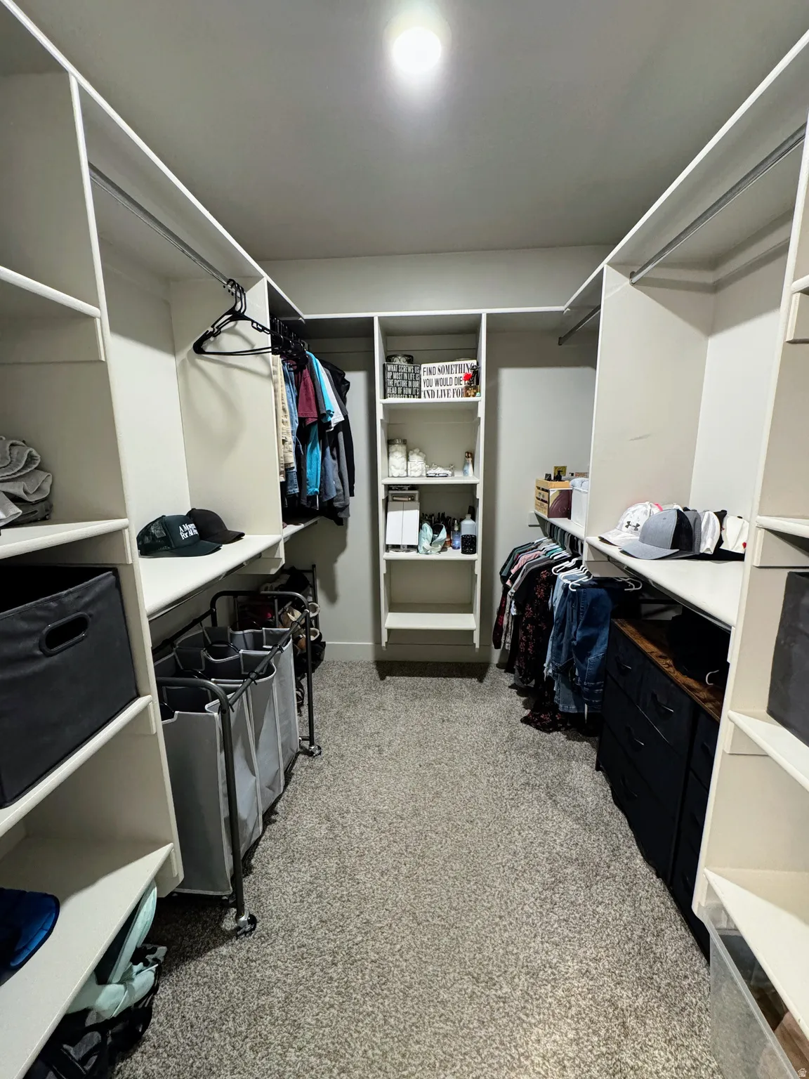 Walk-in closet with built-in shelving, hanging rods, and recessed lighting