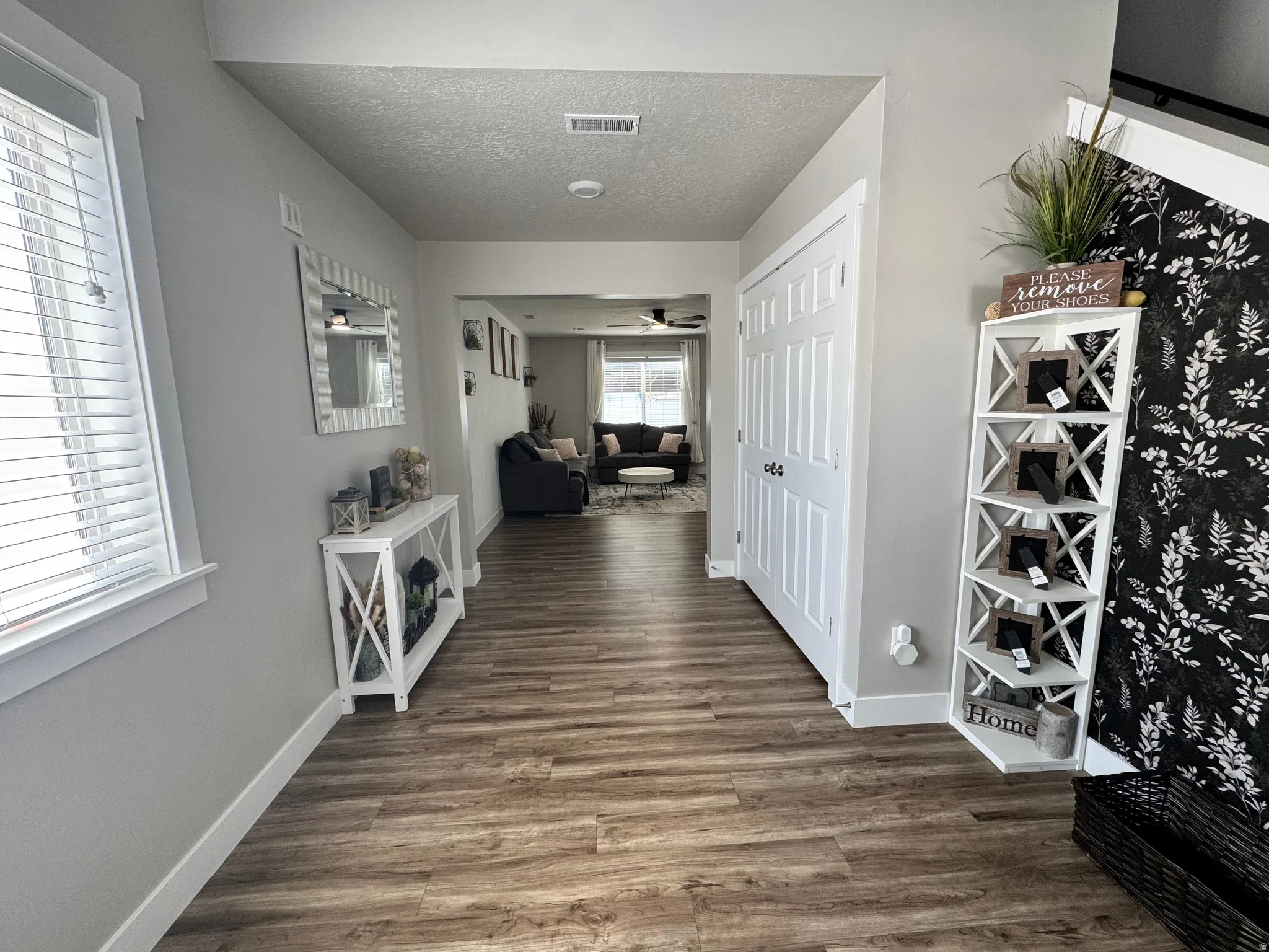 Entryway featuring wood-finish flooring, white trim, and a full-height solid panel door