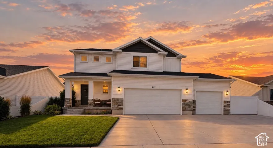 Two-story residence with white siding, dark accent siding, and stone detailing
