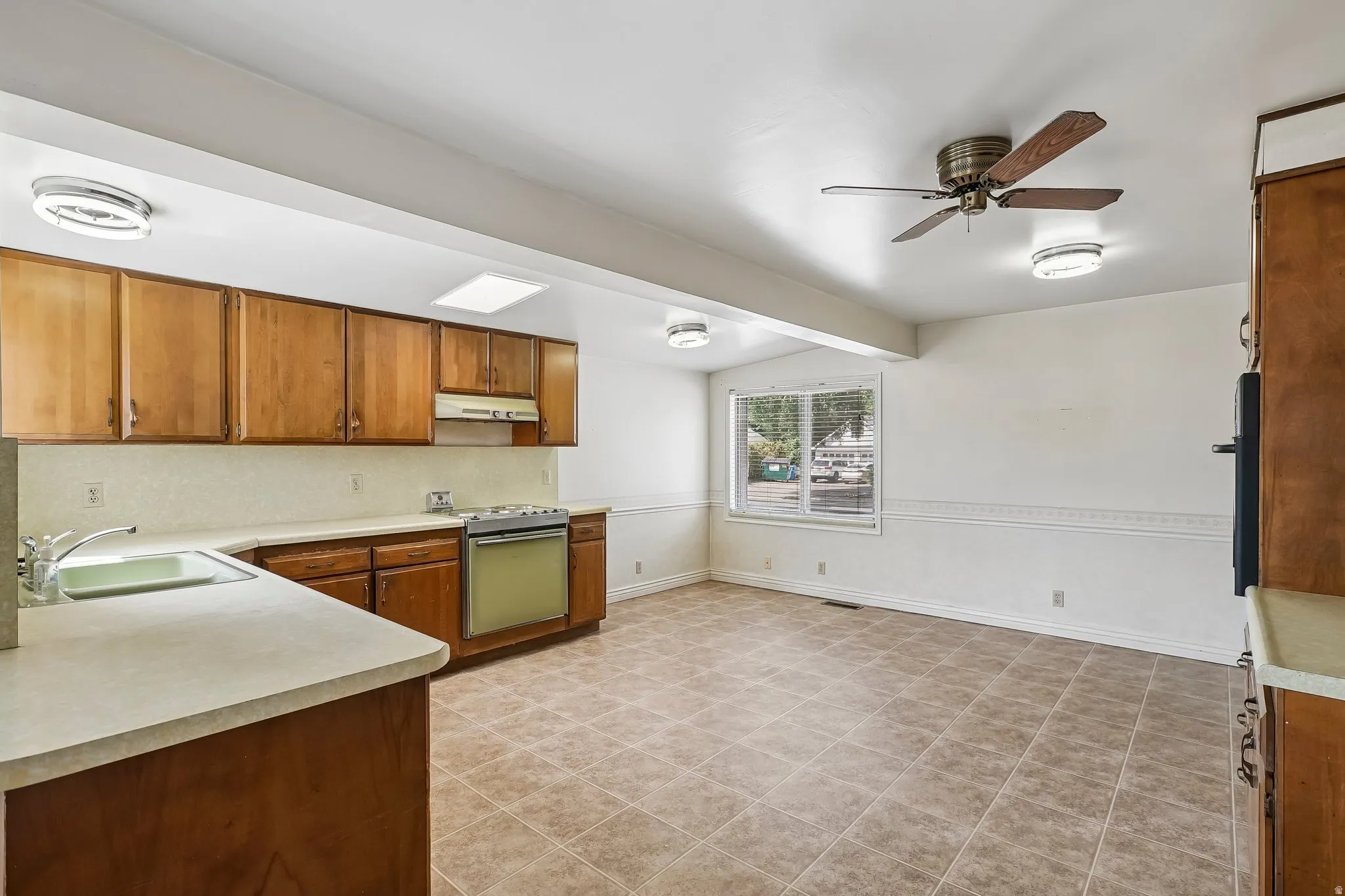 Kitchen featuring wood cabinetry, laminate countertops, and a built-in gas range