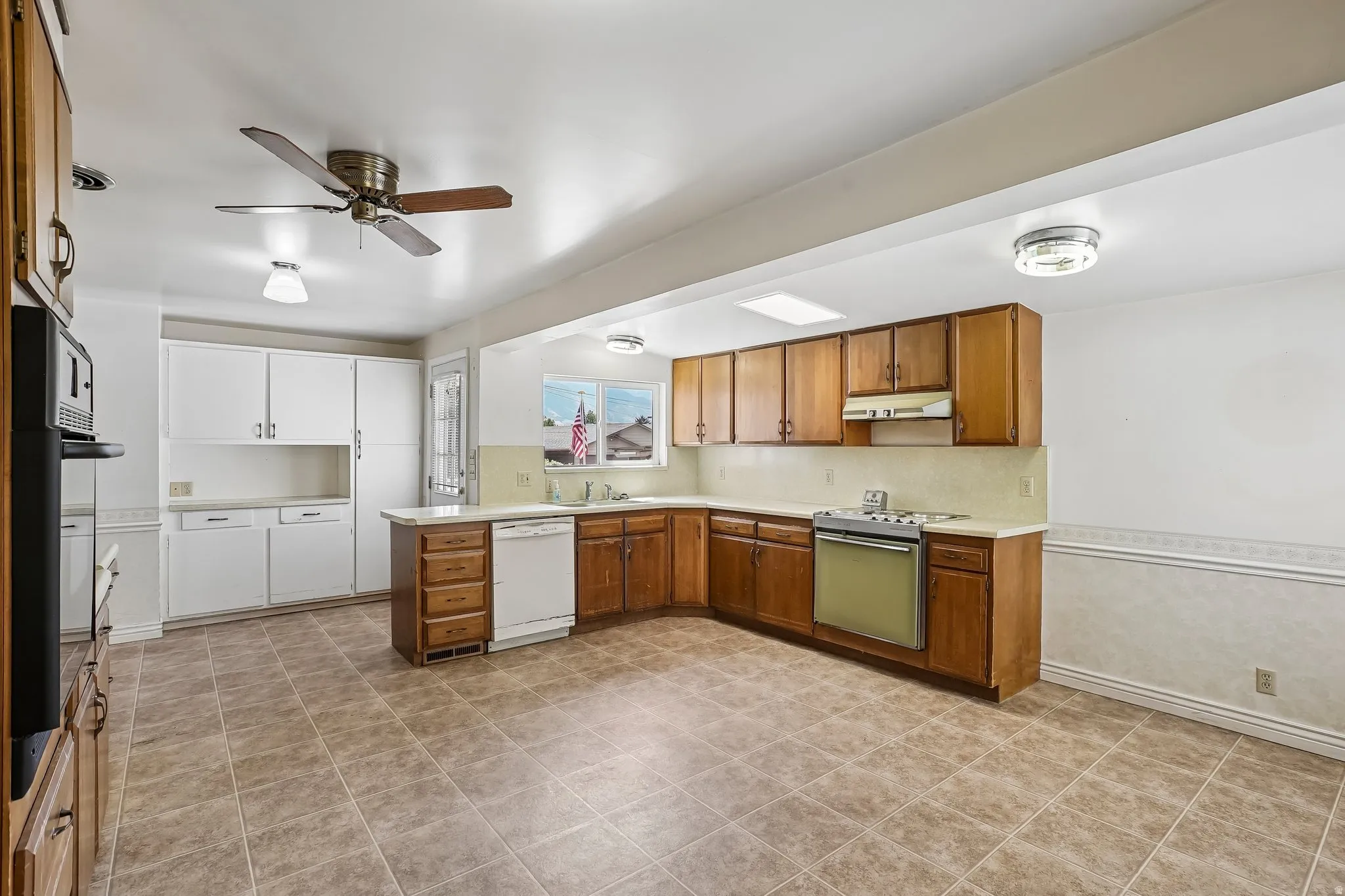 Kitchen featuring wood-finish cabinetry, tile flooring, recessed lighting, and a ceiling fan