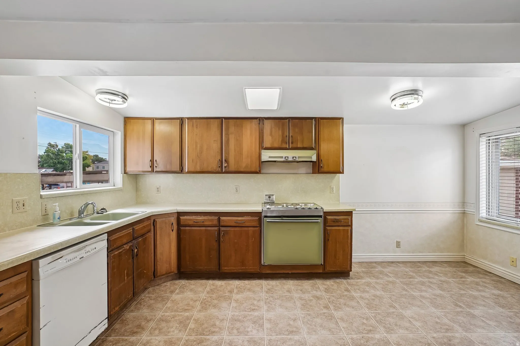 Kitchen featuring wood cabinetry, laminate countertops, and tile flooring