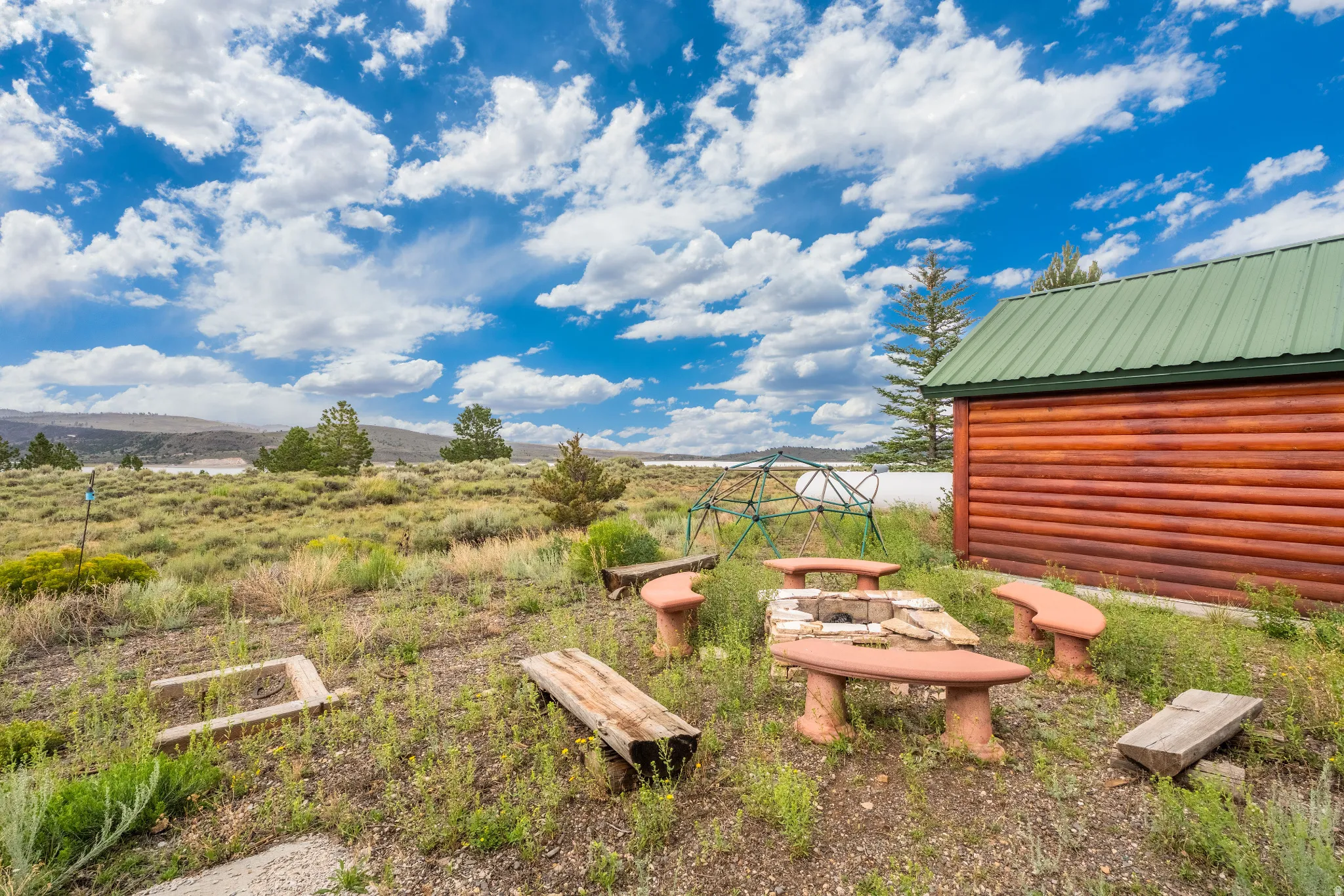 Exterior log cabin siding with a green metal roof