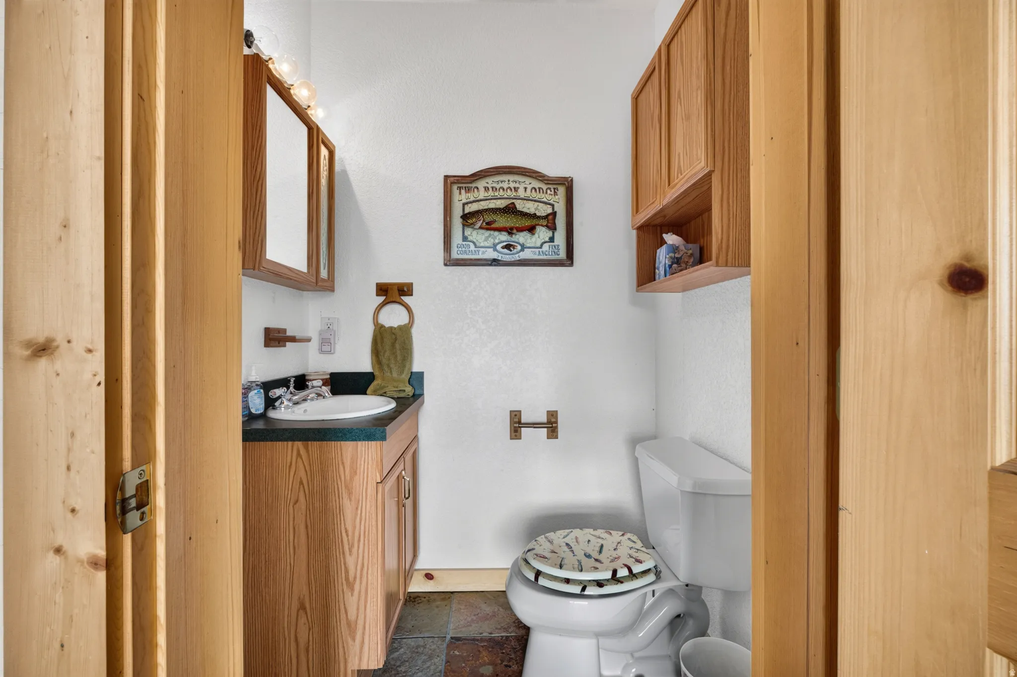 Bathroom vanity with an oval sink and a dark countertop