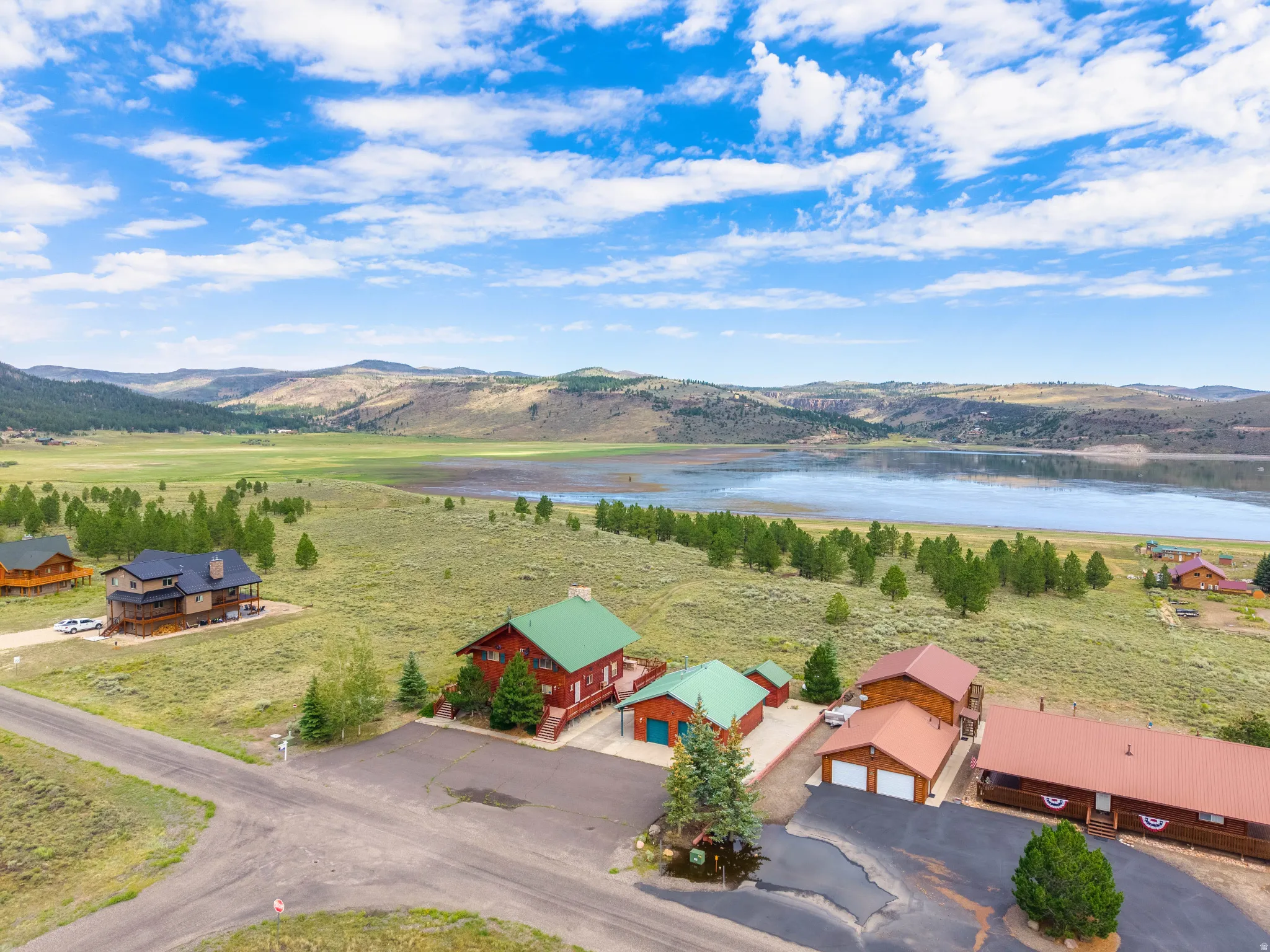Aerial perspective showcasing multiple properties set against a large body of water and distant mountains