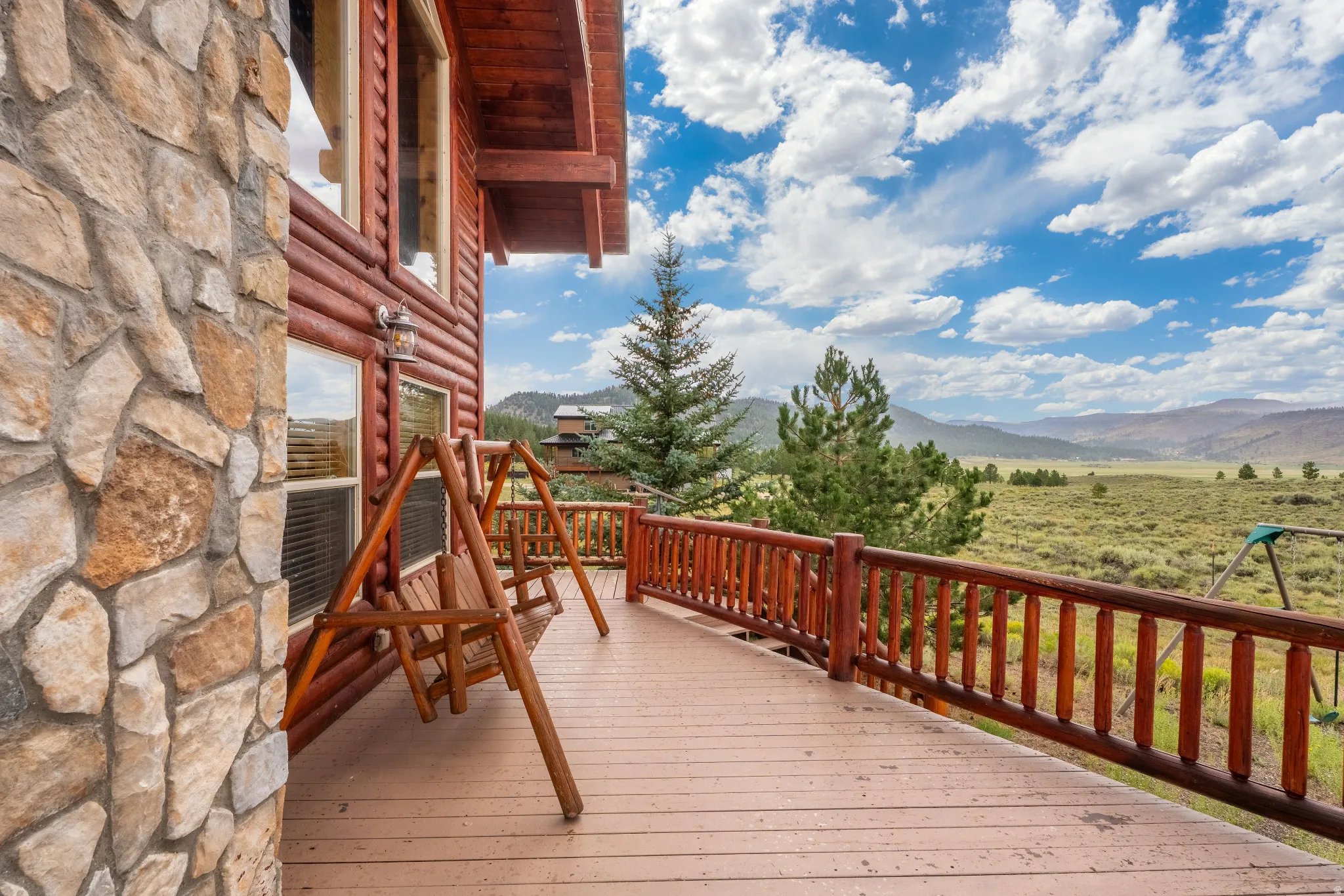 Spacious outdoor deck featuring an exposed timber railing and wood-finish flooring
