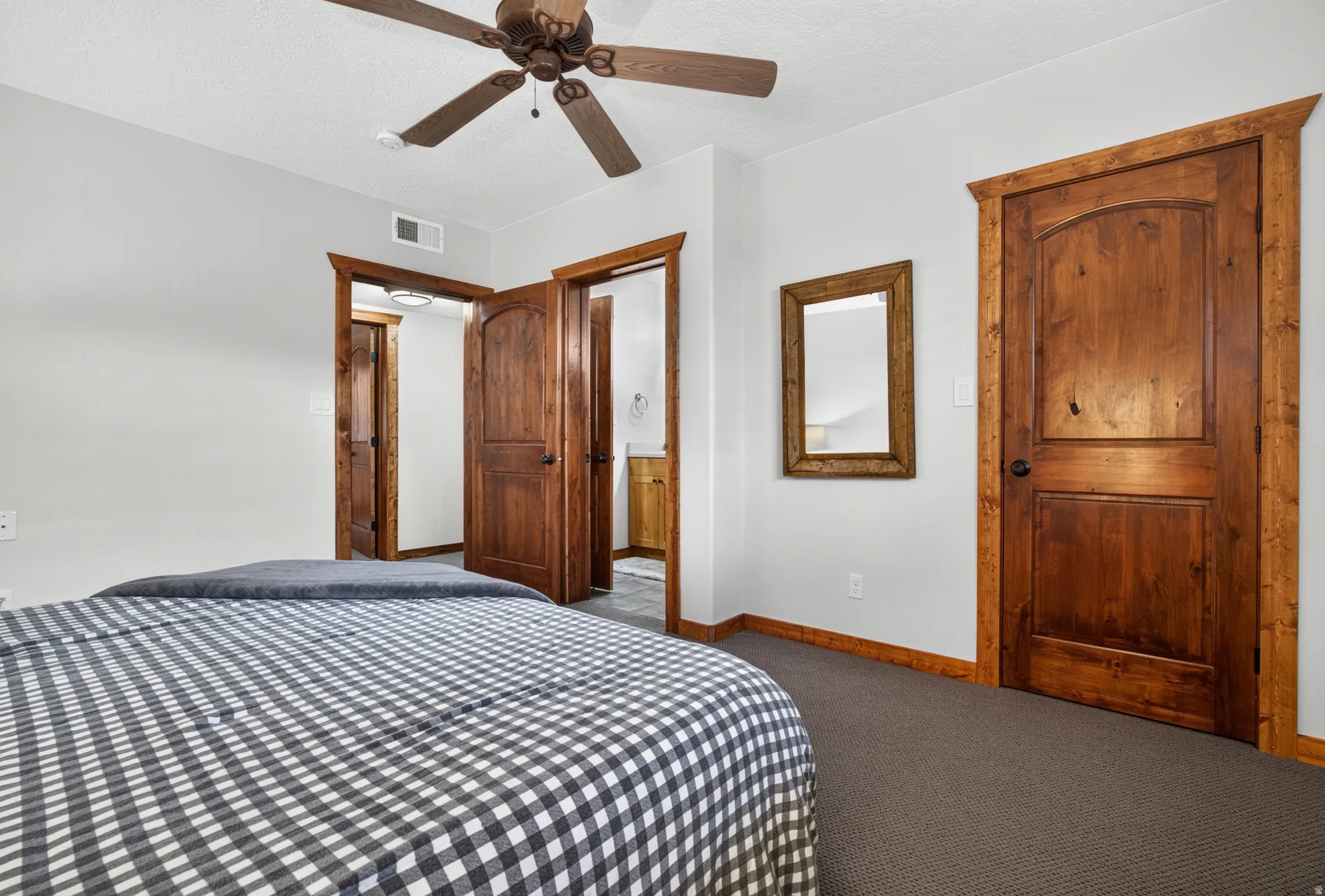 Bedroom featuring dark wood-finish doors, matching trim, and a ceiling fan