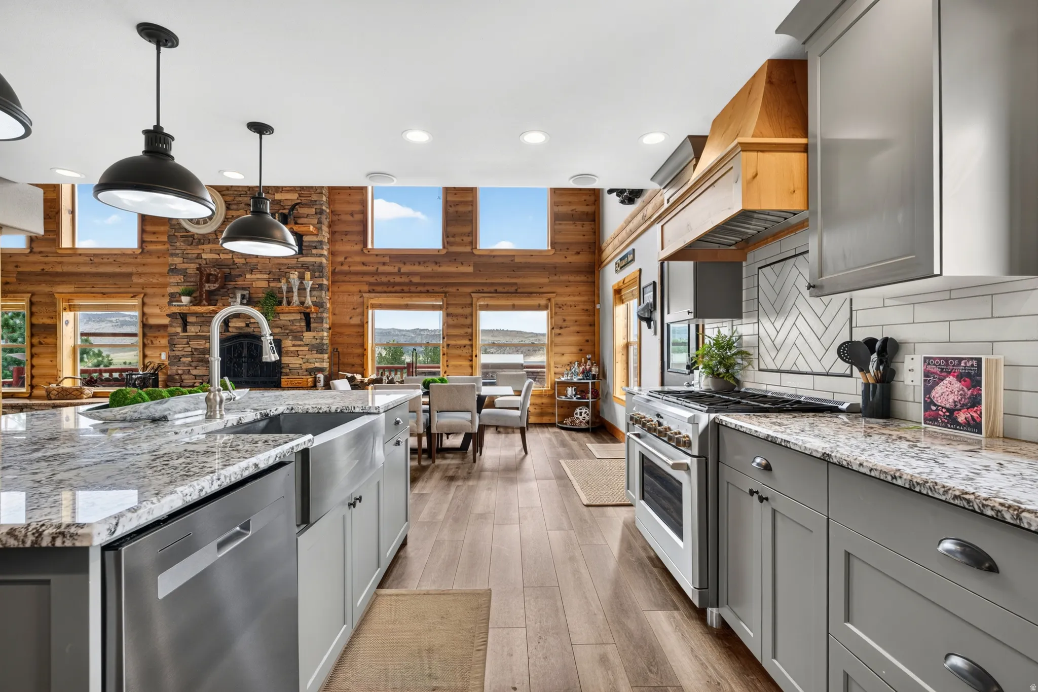 Gourmet kitchen featuring granite countertops, a stainless steel range, and a wood-finish range hood