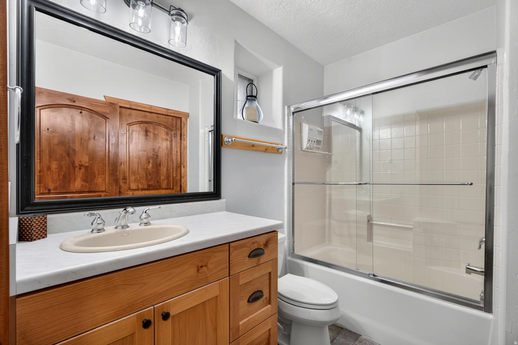 Bathroom featuring a wood-finish vanity with a light countertop and undermount sink