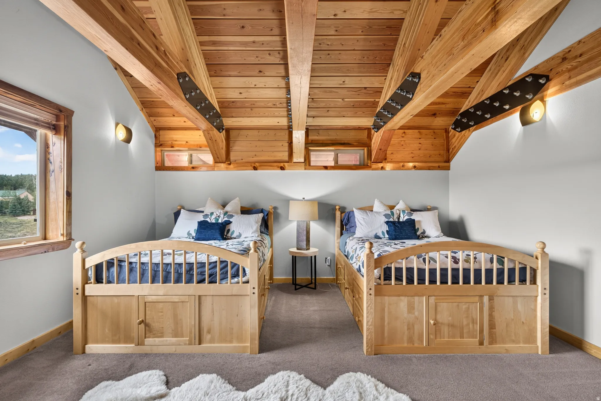 Vaulted wood-paneled ceiling with exposed wood beams, wall-mounted sconces, and a side window