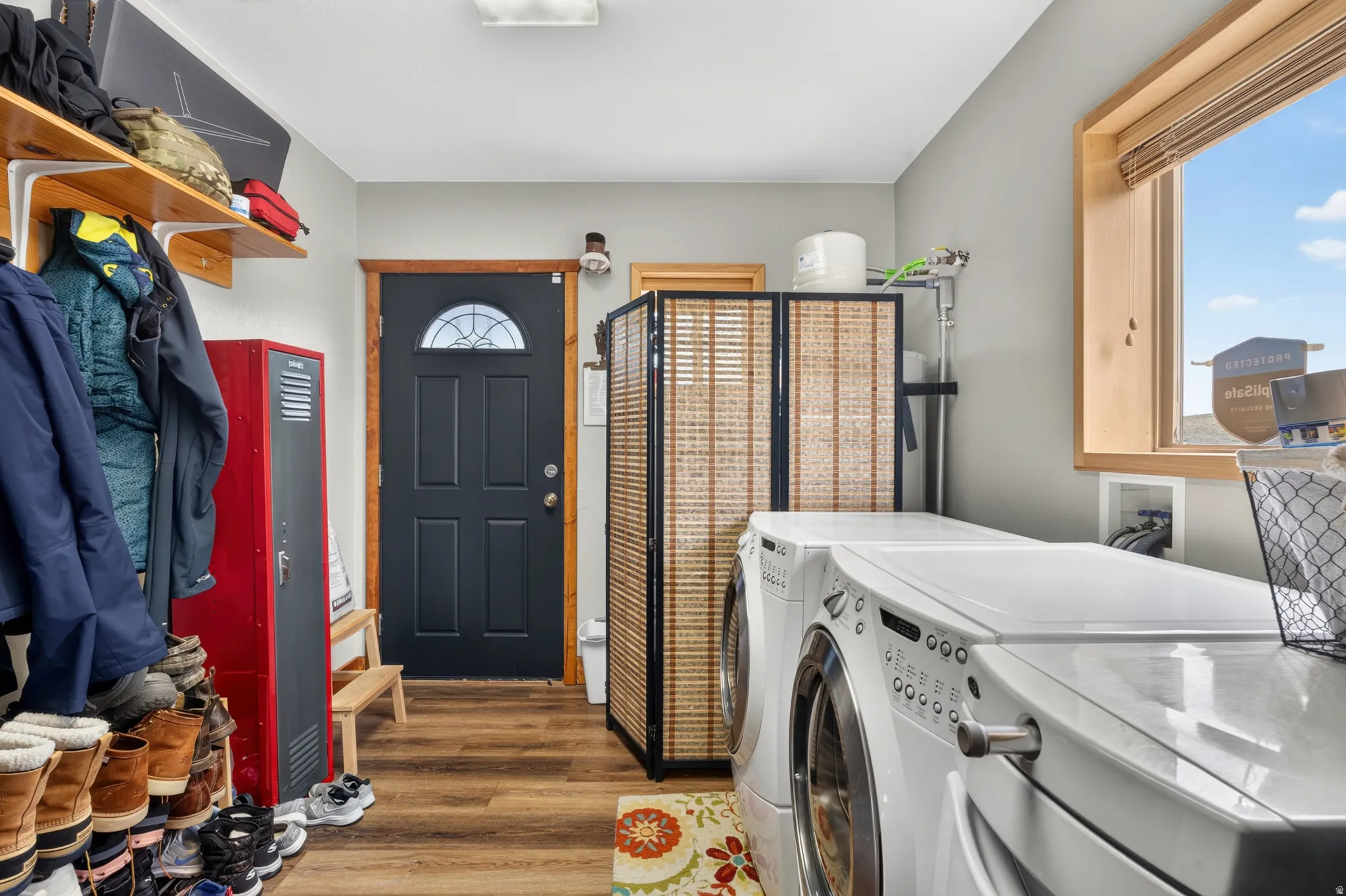 Laundry area with wood-finish flooring, a contemporary window, and ample natural light