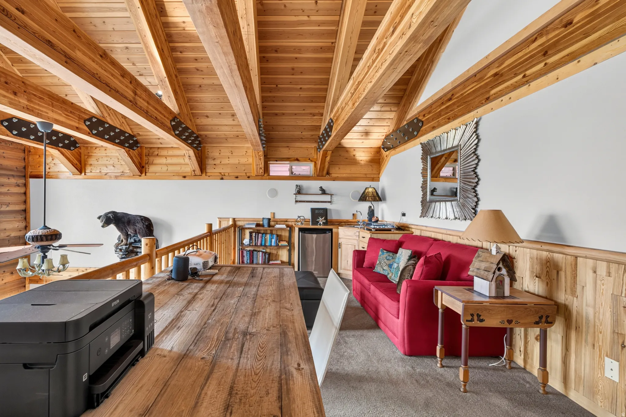 Vaulted wood-paneled ceiling with exposed beams, featuring wood-finish flooring and a built-in wet bar