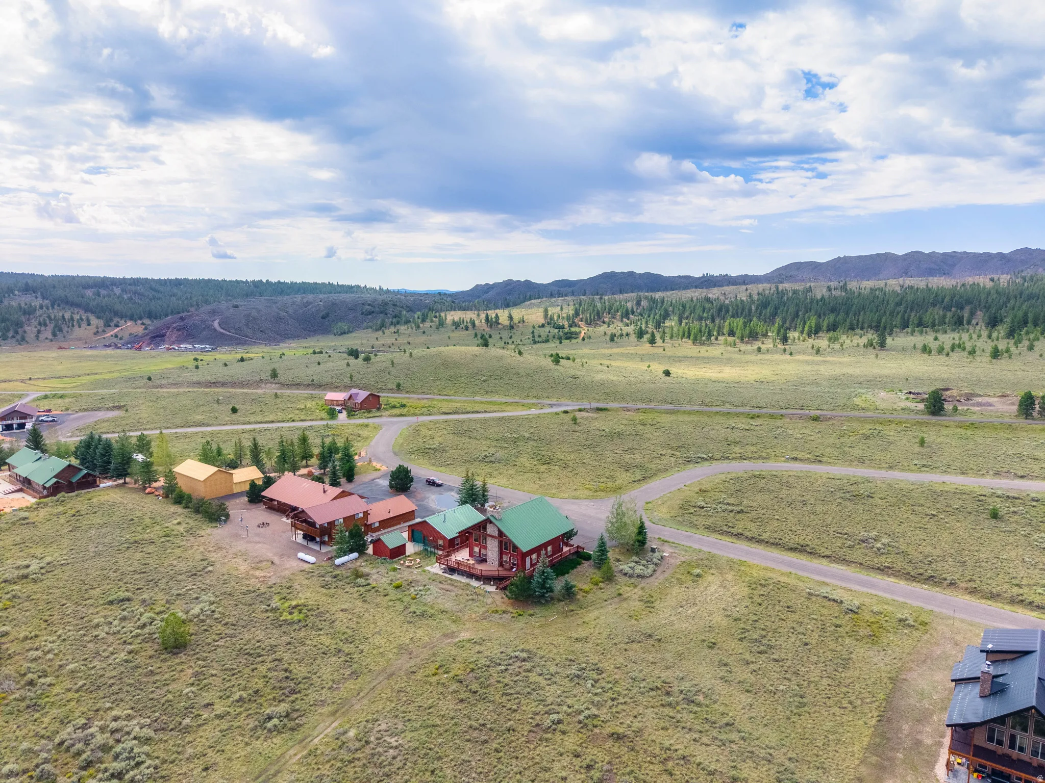 Aerial perspective showcasing multiple properties amidst expansive natural landscape