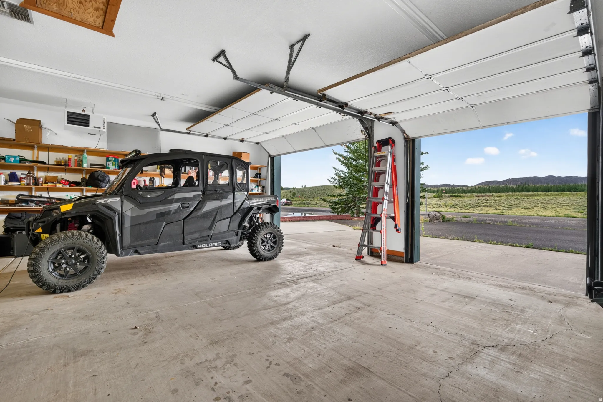 Spacious garage featuring a concrete floor and white paneled garage door