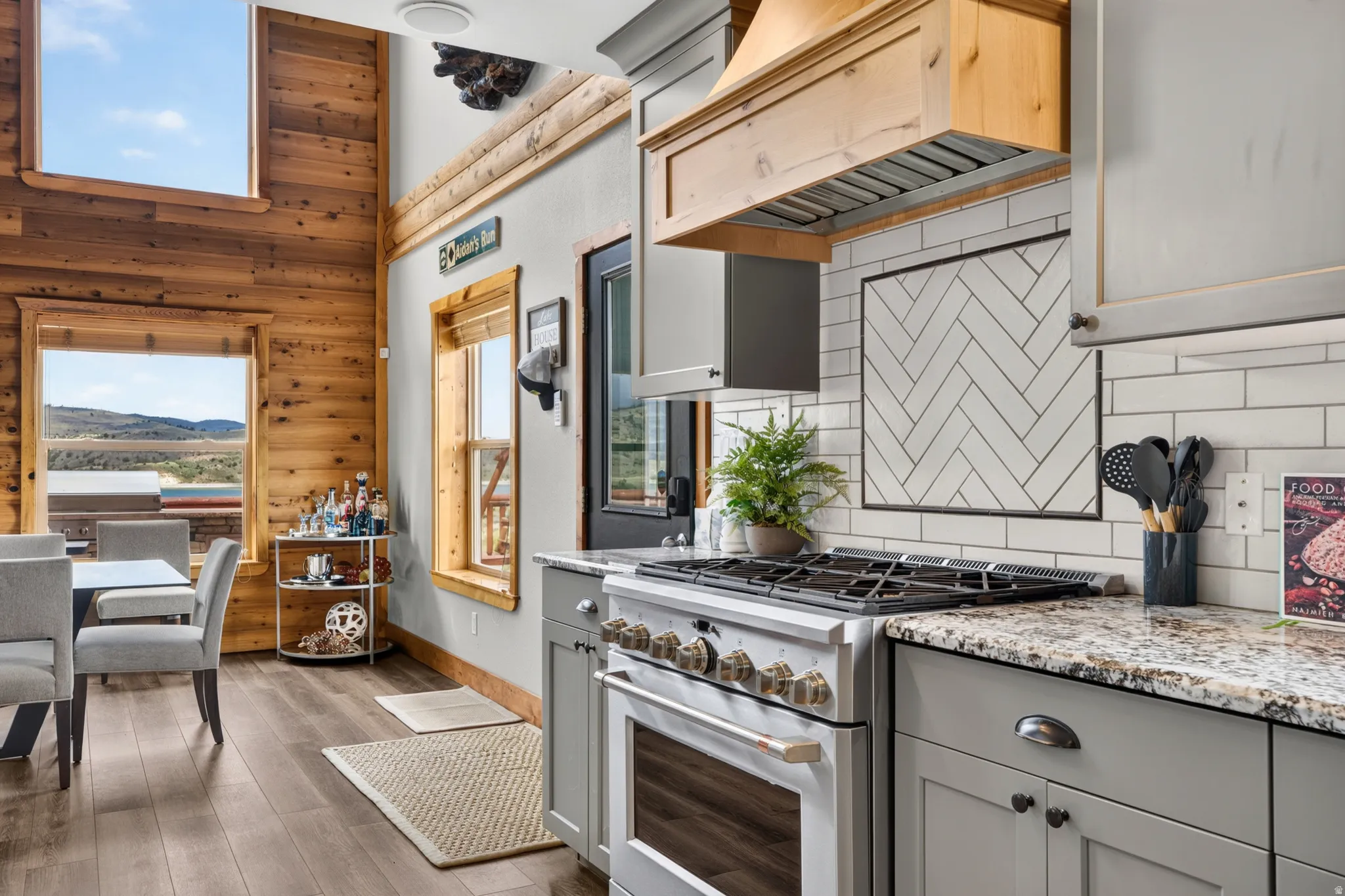 Modern kitchen featuring a stainless steel range, light grey cabinetry, and granite countertops