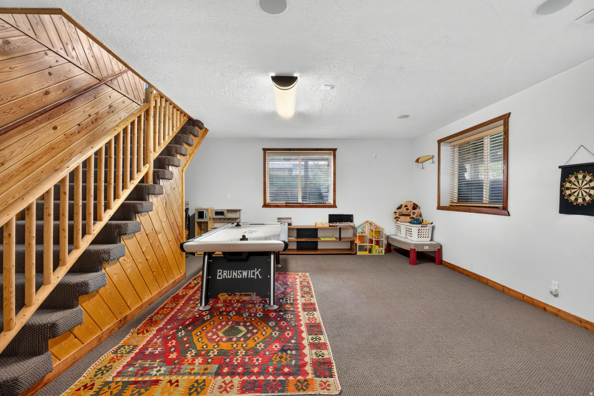 Spacious room featuring wood paneling, wood-framed windows, and built-in ceiling speakers