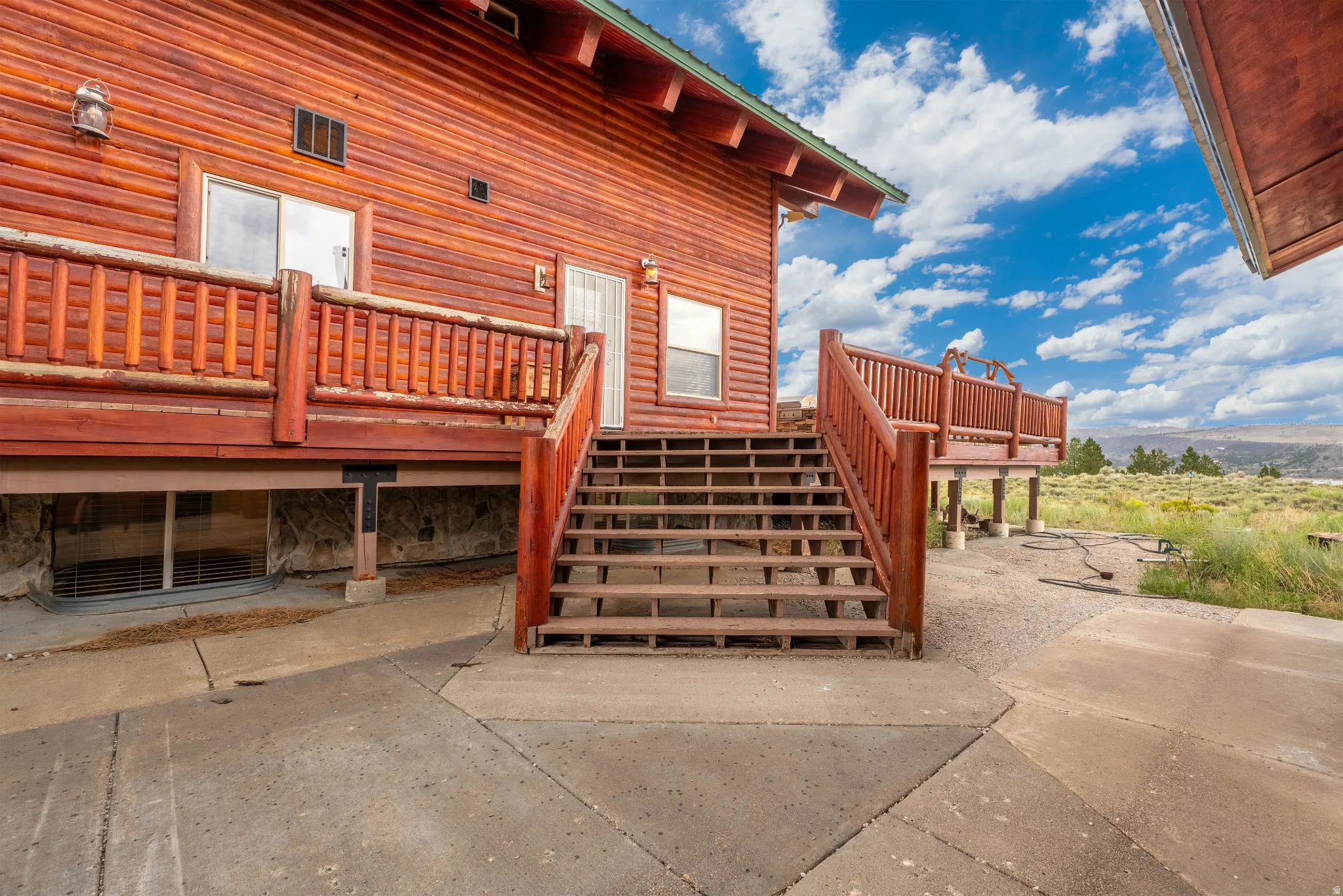 Wood-sided exterior featuring multiple decks, a ground-level patio, and a stone foundation
