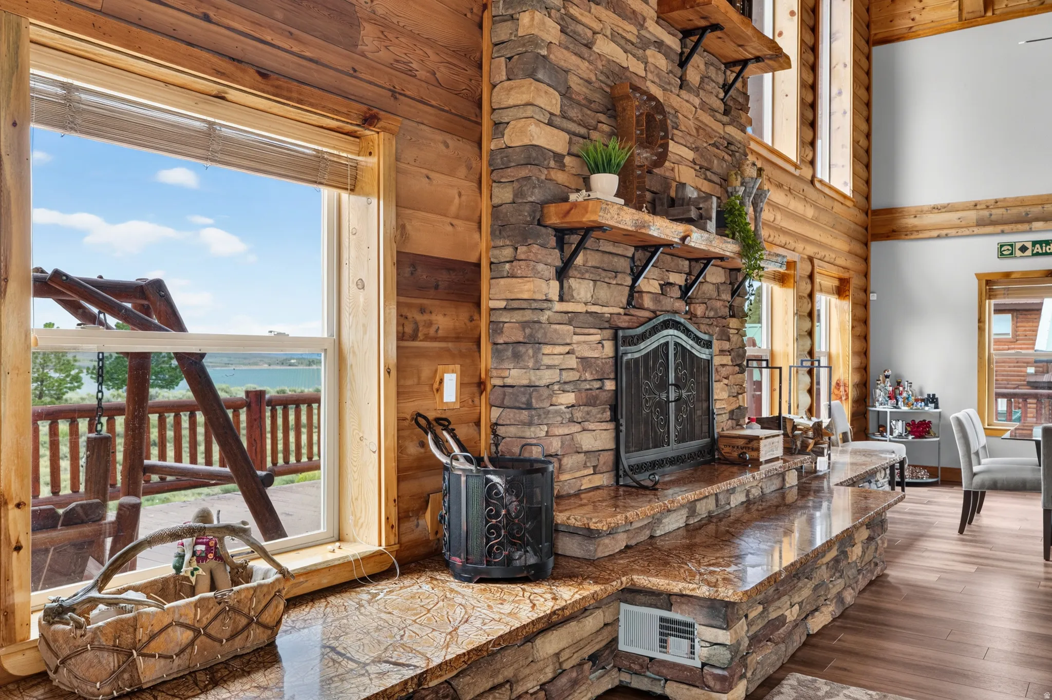 Stacked stone fireplace featuring an ornate screen, granite hearth, and integrated shelving