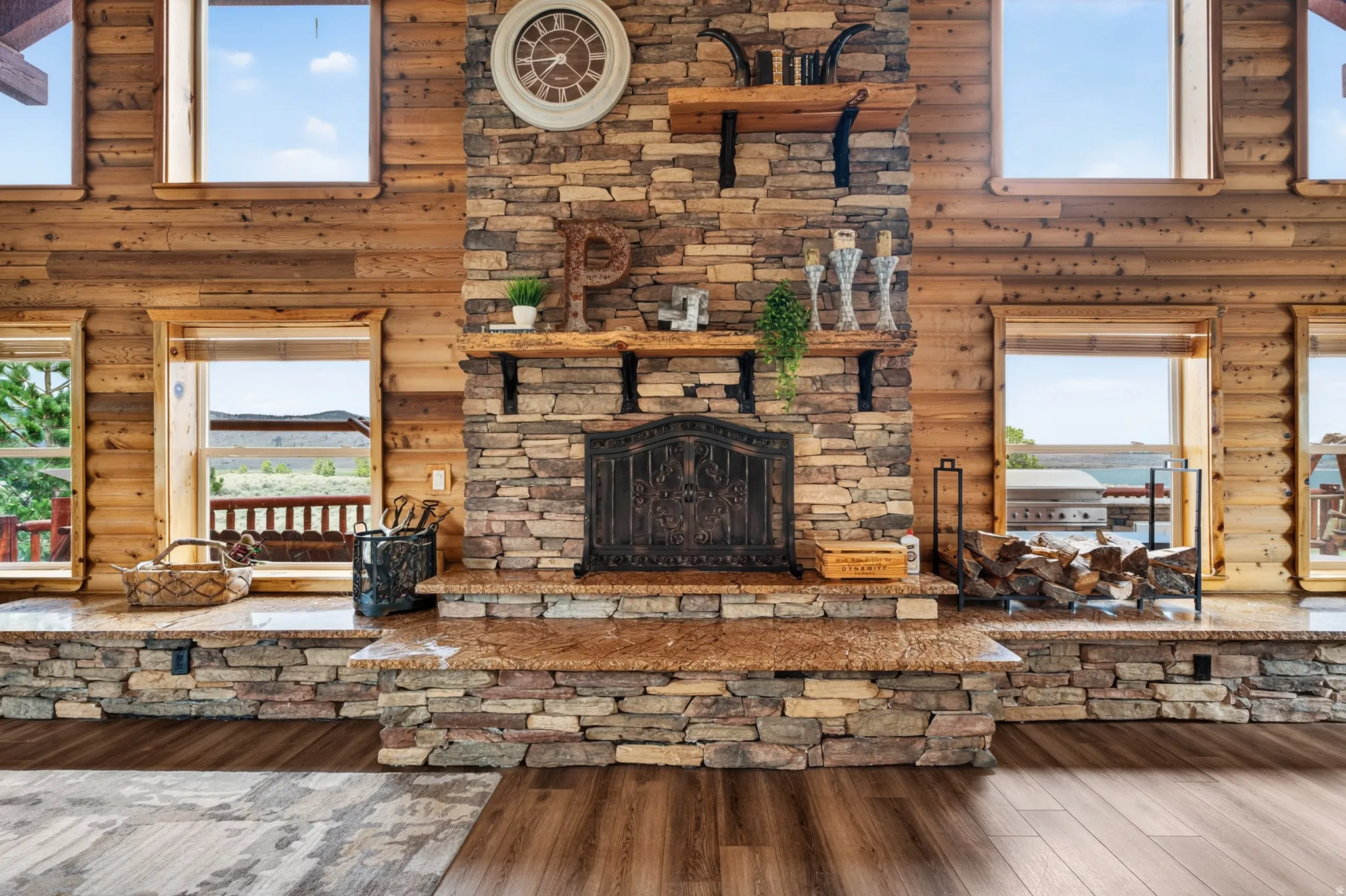 Stacked stone fireplace with a rustic wood mantel and hearth