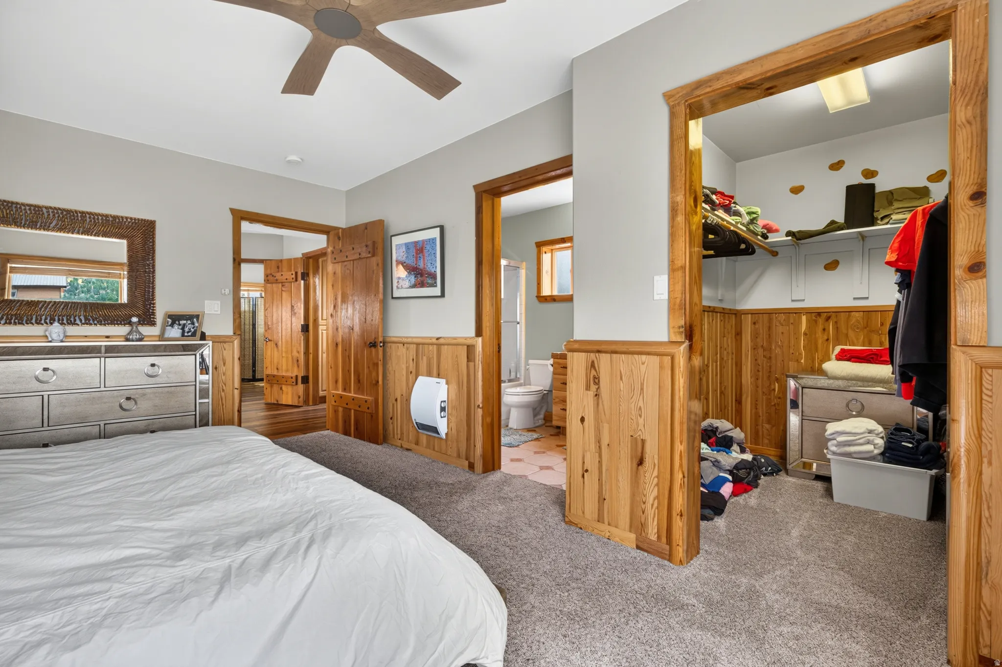 Bedroom featuring light gray walls, wood-finish wainscoting, and carpet flooring