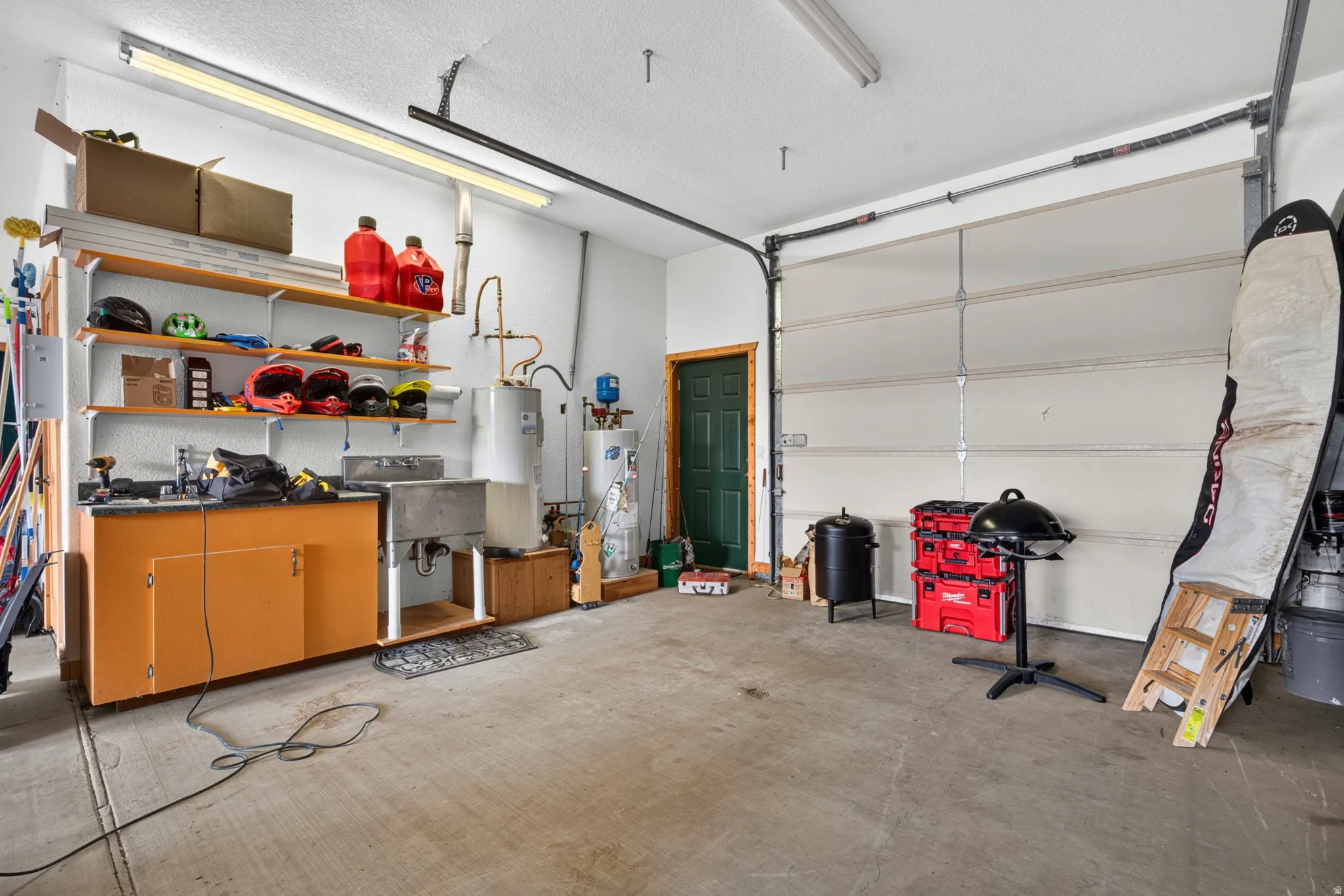 Spacious garage with exposed concrete flooring, white walls, and bright overhead lighting